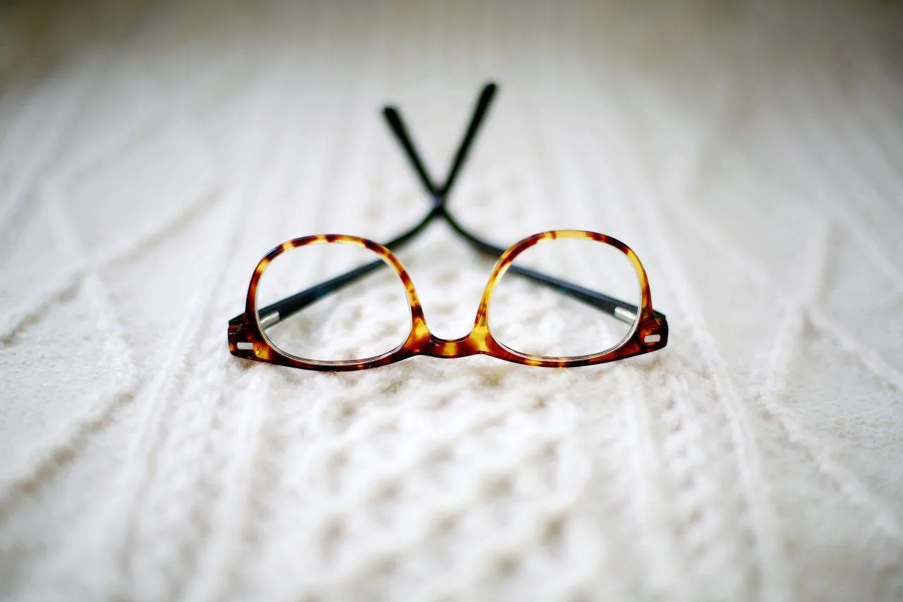 Tortoiseshell eyeglasses resting on a knit sweater