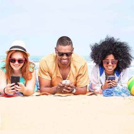 Group of friends wearing sunglasses and smiling on beach