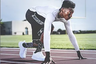 Male athlete in starting stance on outdoor running track