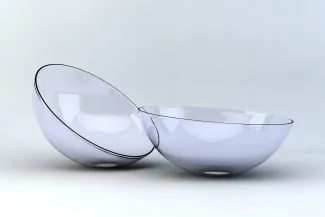 Close-up of two contact lenses on a white reflective surface