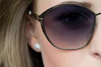 Close-up of woman in dark sunglasses with pearl earring