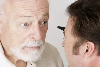 Elderly man getting vision test from female eye care provider