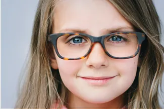 Smiling young girl wearing tortoiseshell eyeglass frames